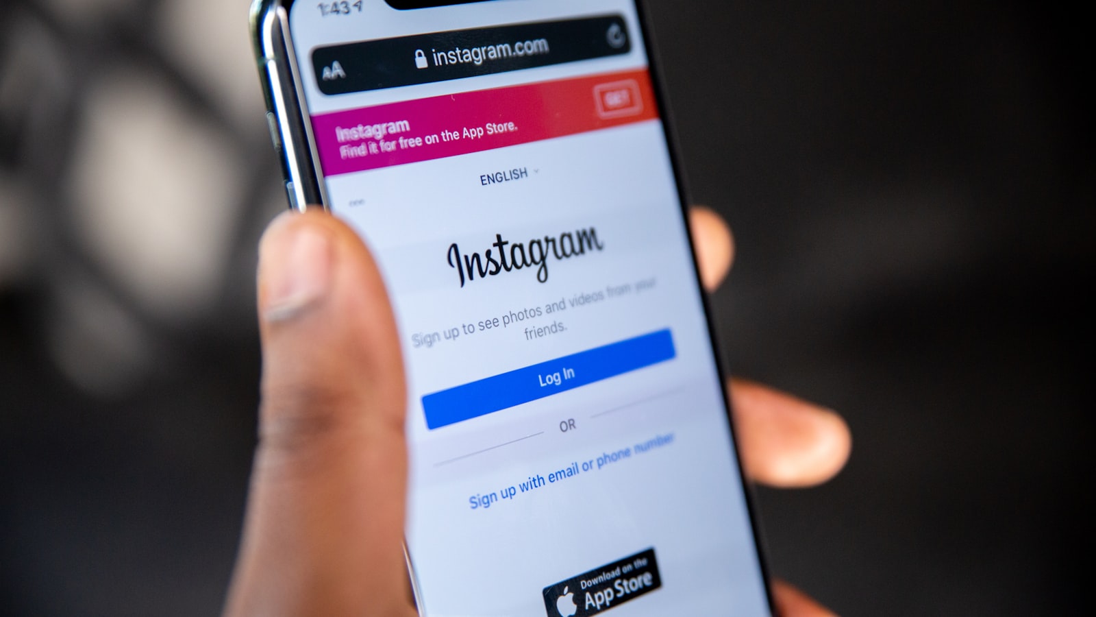 Main tenant un smartphone affichant un profil Instagram